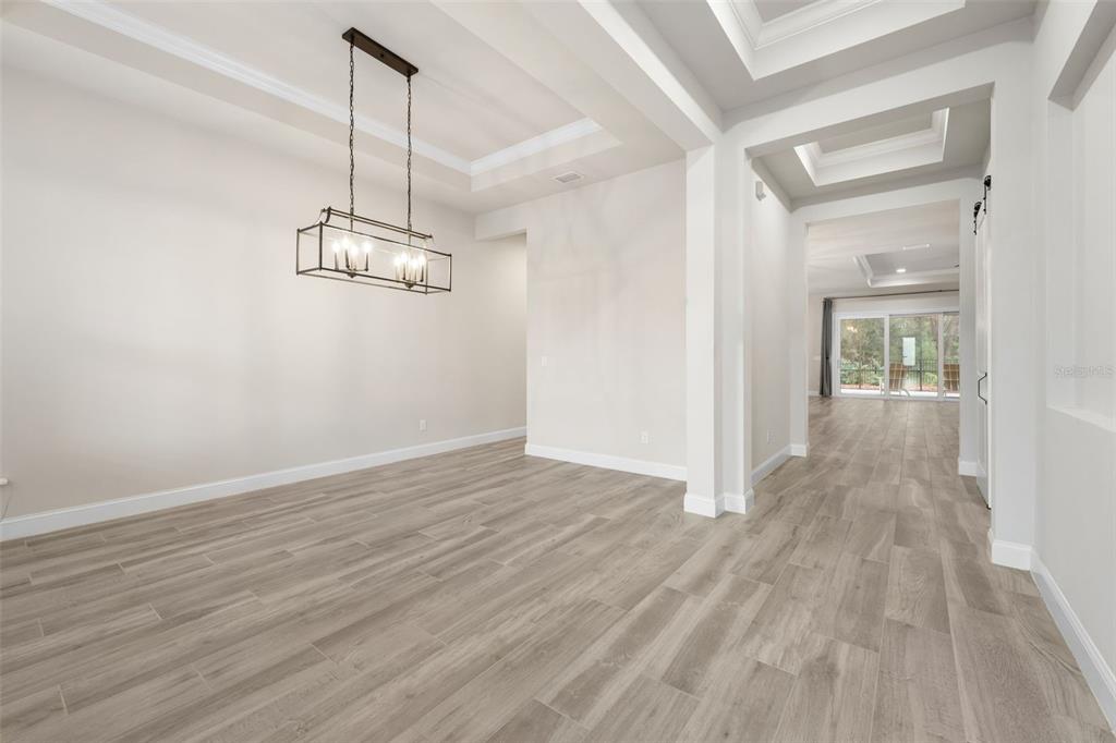 11081 Southwest 38th Boulevard Gainesville, FL 32608 - Photo 5 of 66 a view of a room with wooden floor and kitchen view