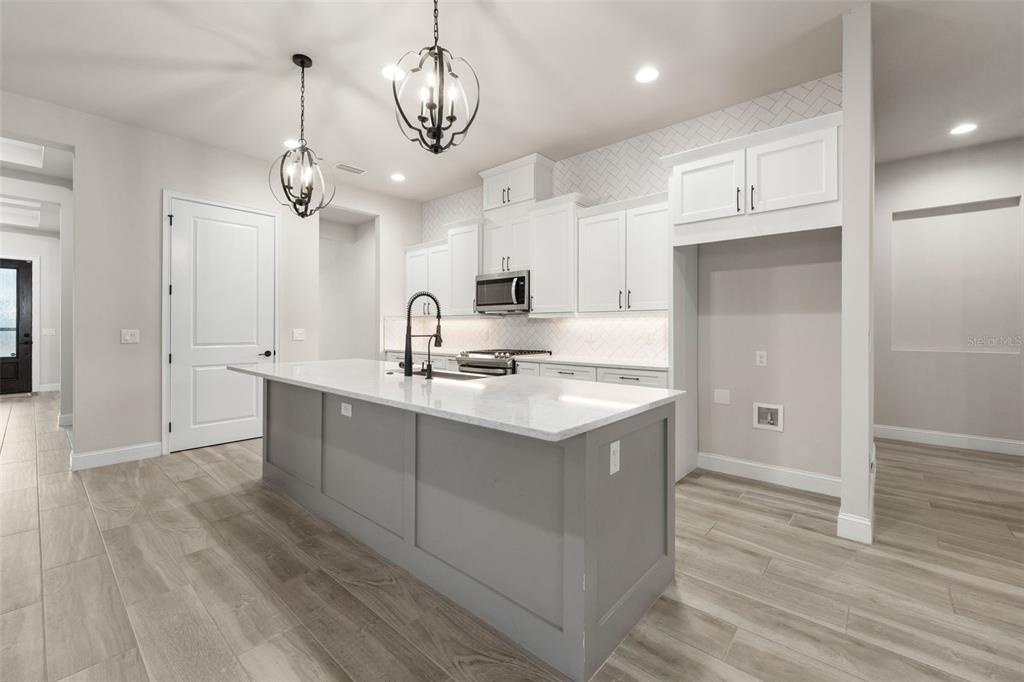 11081 Southwest 38th Boulevard Gainesville, FL 32608 - Photo 10 of 66 a kitchen with granite countertop a sink cabinets and wooden floor