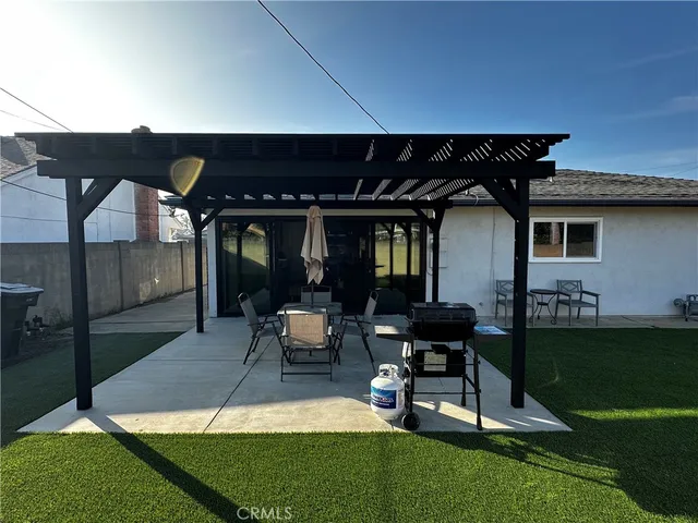 a patio with a table and chairs and potted plants