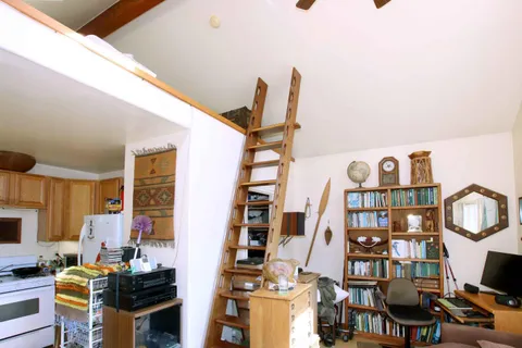 a bedroom with a bed and flat tv screen on dresser