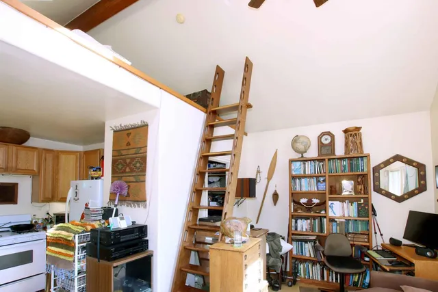 a bedroom with a bed and flat tv screen on dresser