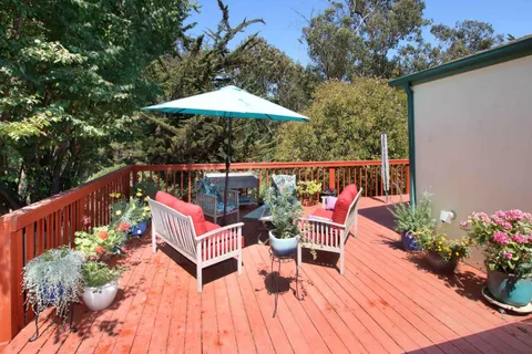 a backyard of a house with a garden and outdoor seating
