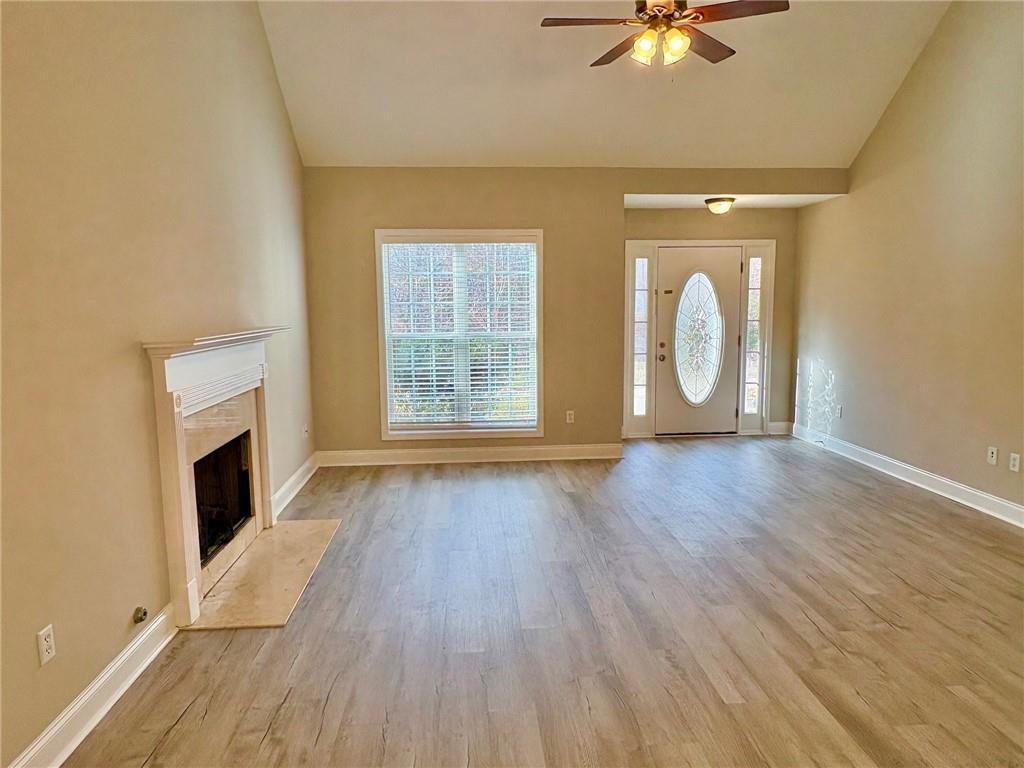 41 Oakmont Drive Southwest Rome, GA 30161 - Photo 7 of 21 wooden floor in an empty room with a fireplace and a window
