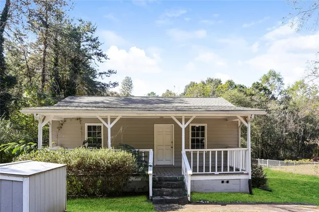 a view of a house with a yard and potted plants