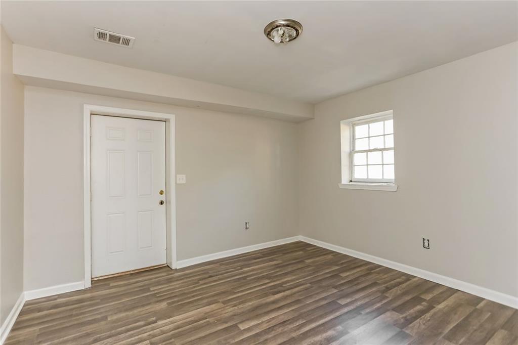 4179 Williamson Road Ellenwood, GA 30294 - Photo 18 of 25 an empty room with wooden floor and windows