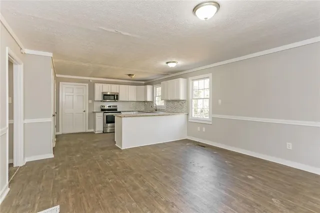 a view of kitchen with wooden floor and electronic appliances