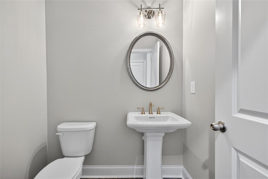 8845 Jot Em Down Road Gainesville, GA 30506 - Photo 31 of 87 a bathroom with a toilet sink and mirror