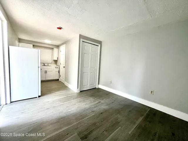 a view of a kitchen with a sink and a refrigerator