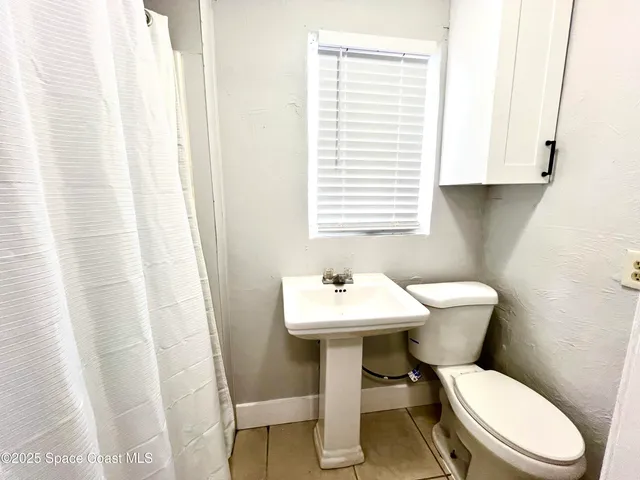 a white toilet sitting next to a bathroom sink