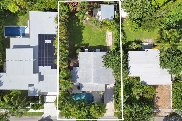 an aerial view of a house with a yard and large trees