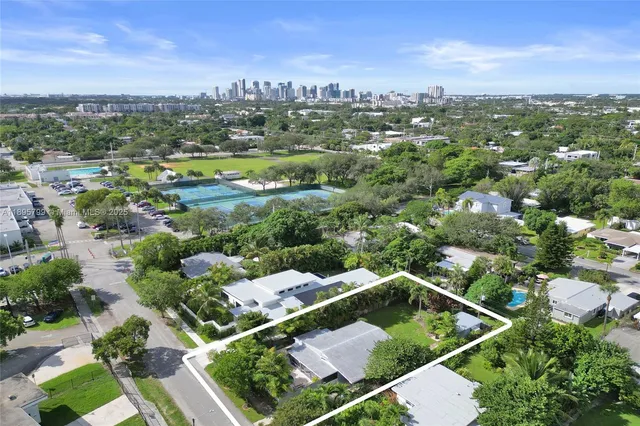 an aerial view of residential houses with outdoor space and city view