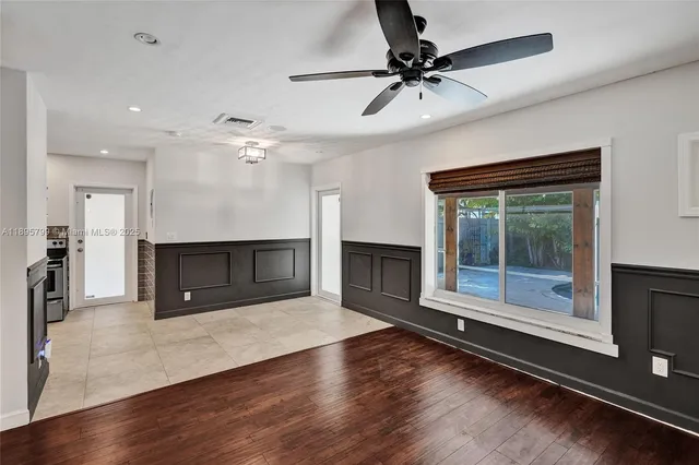 an empty room with wooden floor a fireplace and windows