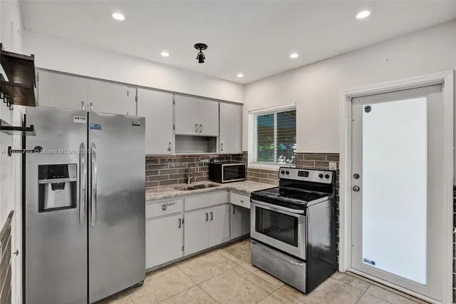 a kitchen with stainless steel appliances a refrigerator sink and stove
