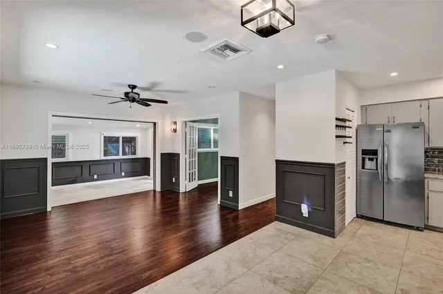 an empty room with wooden floor fireplace and windows