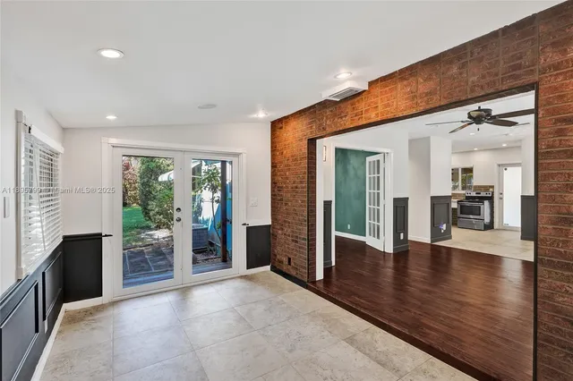 a view of a hallway with wooden floor and a kitchen