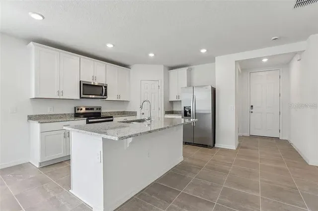 a kitchen with a refrigerator a sink and cabinets