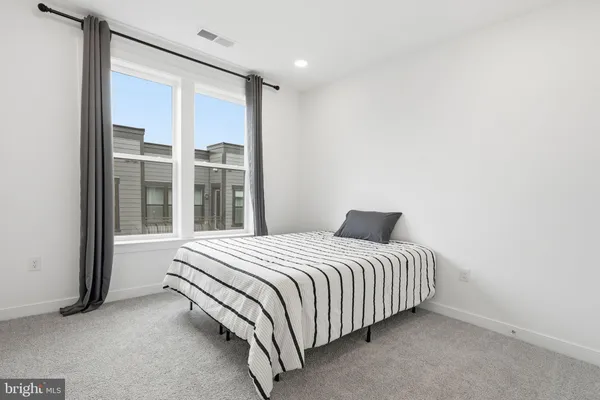 a bedroom with a bed and a large window