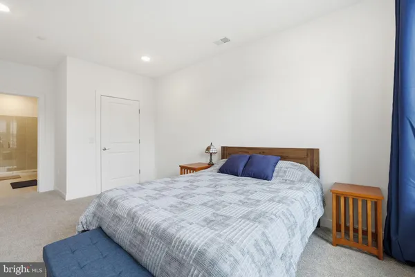 a bedroom with a large bed and a chandelier