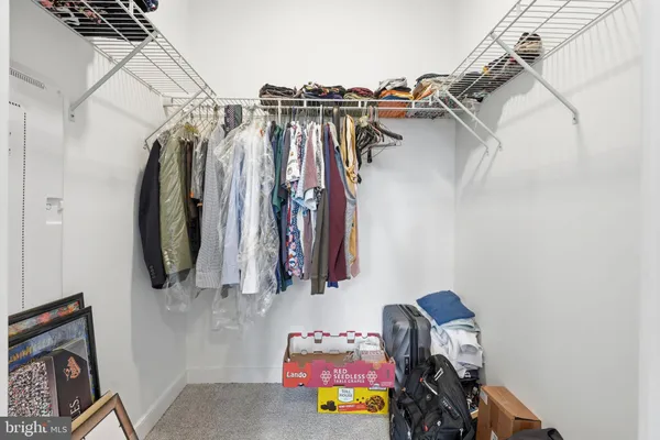 a view of walk in closet with clothes and shoes