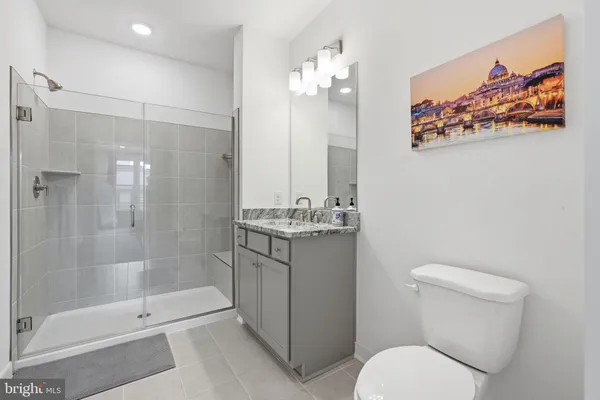 a bathroom with a granite countertop sink a toilet and shower