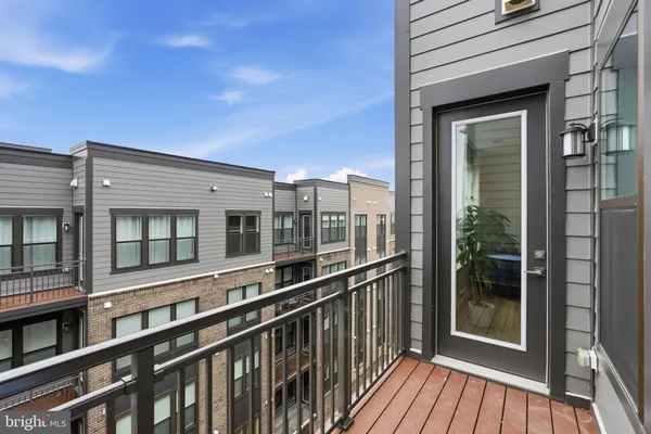 a view of a balcony with a large window and wooden fence