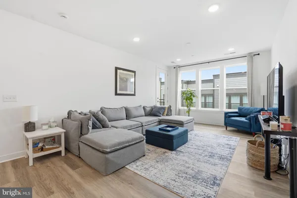 a living room with furniture flat screen tv and a large window
