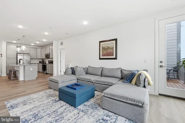 a living room with furniture and kitchen view