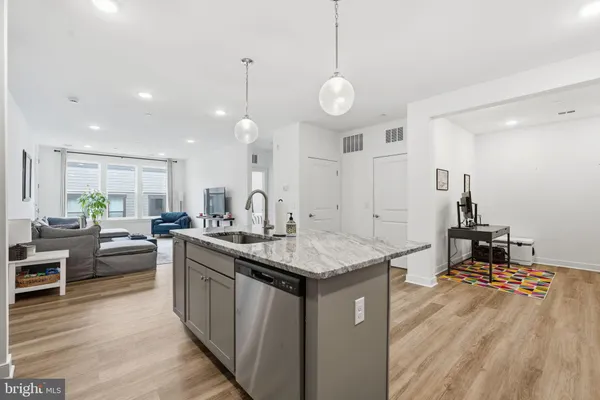 a kitchen with stainless steel appliances granite countertop a sink a stove and a wooden floors