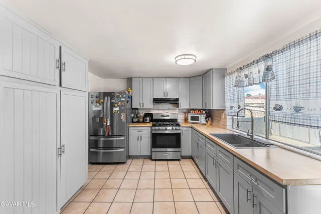 a kitchen with granite countertop a refrigerator and a stove top oven