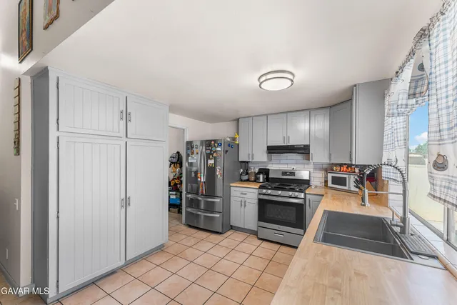 a kitchen with a sink window and stainless steel appliances