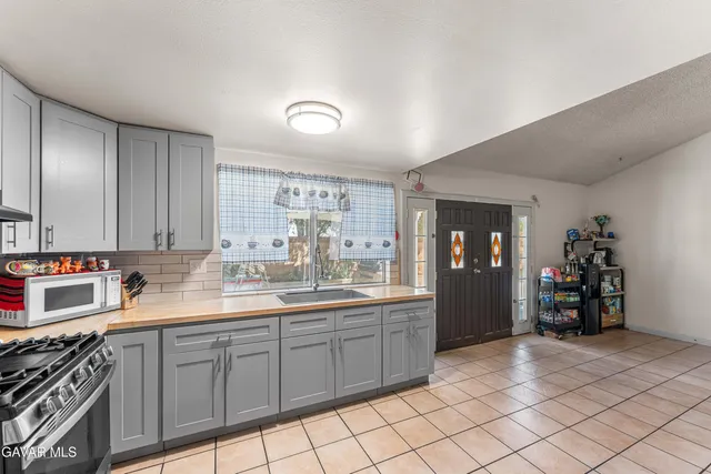 a kitchen with kitchen island granite countertop a sink cabinets and stainless steel appliances