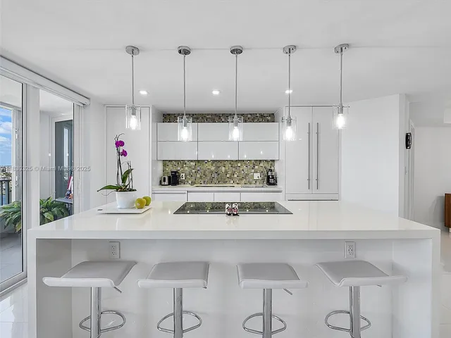 a view of a kitchen with kitchen island stainless steel appliances and wooden floor