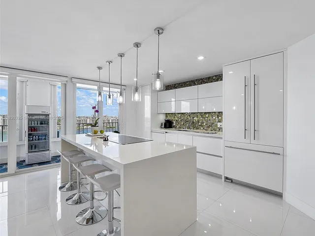 a kitchen with white cabinets and refrigerator