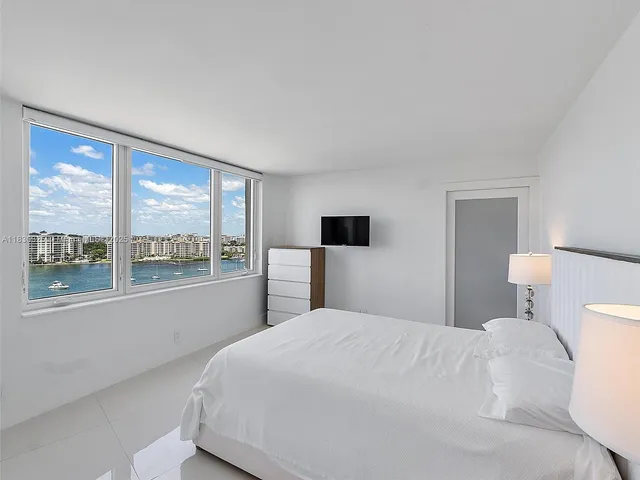a bedroom with a large bed and a large window