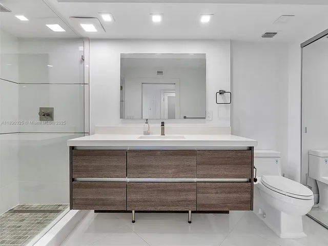 a bathroom with a sink a toilet and a mirror