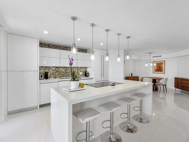 a kitchen with kitchen island a white table and chairs