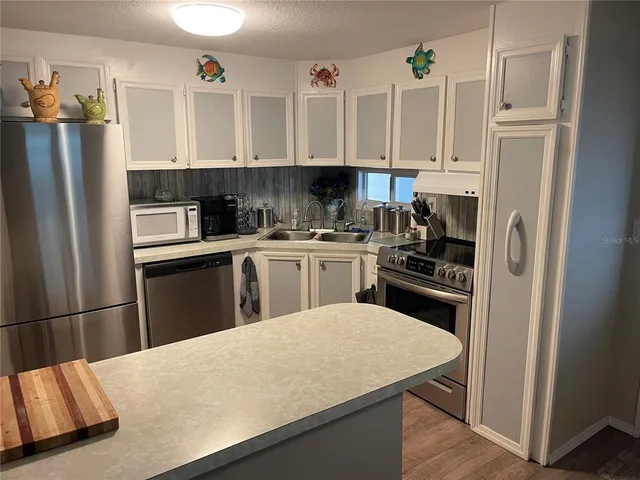 a kitchen with stainless steel appliances a refrigerator sink and cabinets