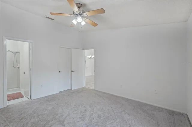 an empty room with a fan & a ceiling fan
