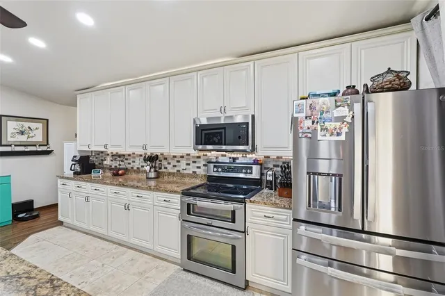 a kitchen with stainless steel appliances white cabinets and a refrigerator