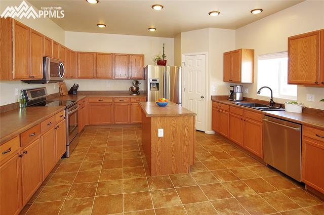 9352 St.George Road Peyton, CO 80831 - Photo 6 of 25 Large kitchen with stainless steel appliances, island, and pantry