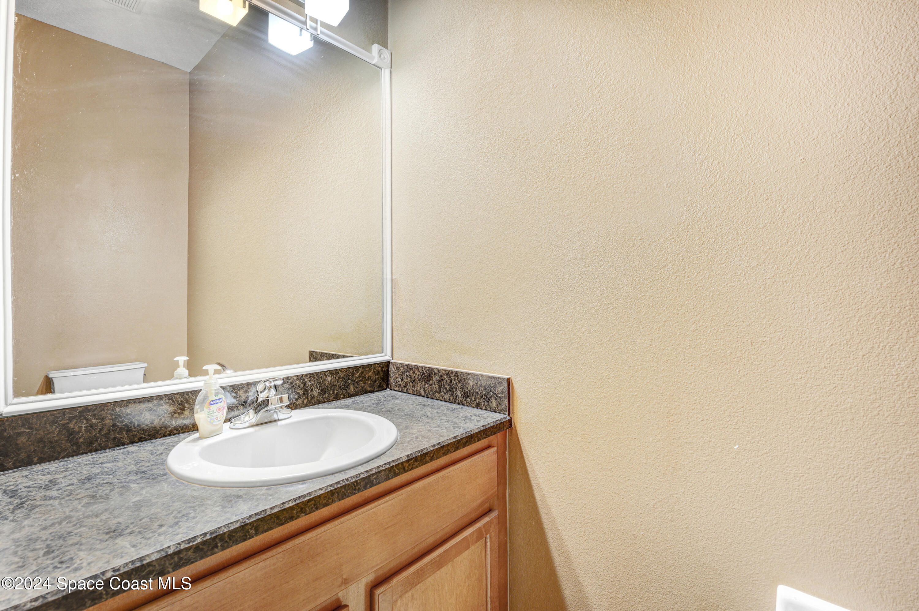 2785 Reston Street, Unit 103 Melbourne, FL 32935 - Photo 26 of 44 a bathroom with a granite countertop sink and a mirror