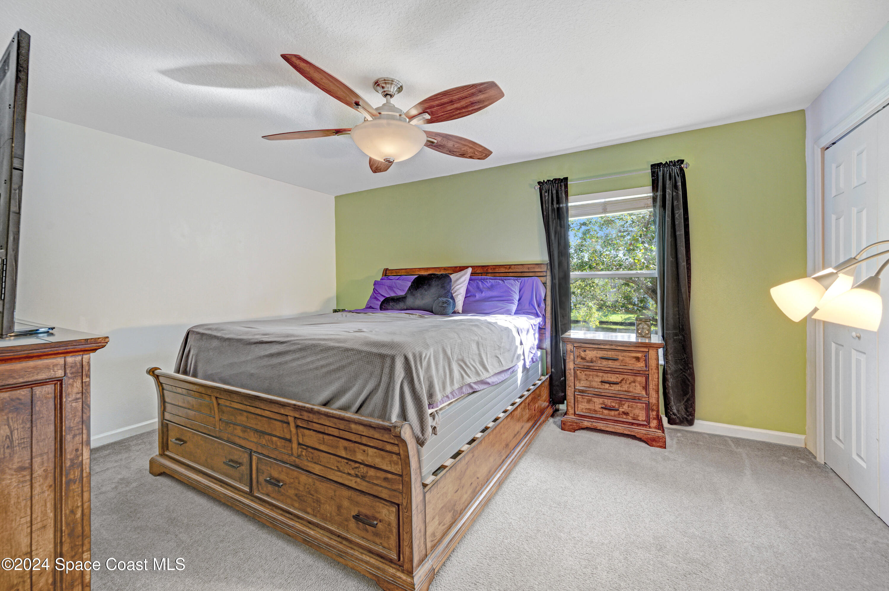 2785 Reston Street, Unit 103 Melbourne, FL 32935 - Photo 38 of 44 a bedroom with a bed and a chandelier
