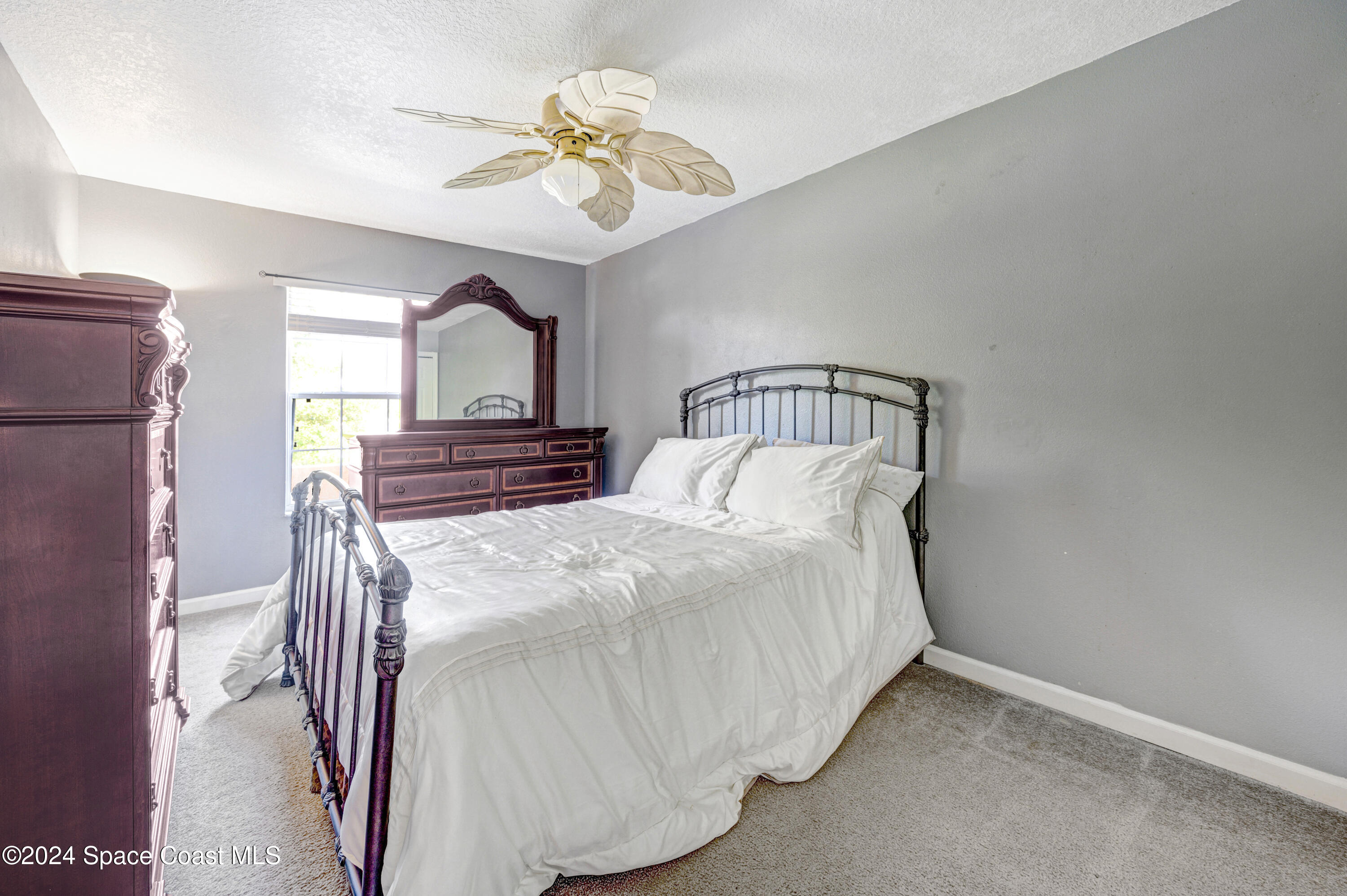2785 Reston Street, Unit 103 Melbourne, FL 32935 - Photo 43 of 44 a bedroom with a bed and a chandelier