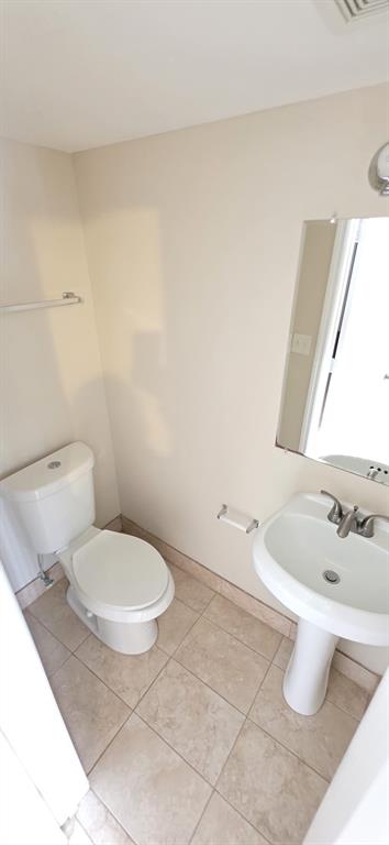1940 Northwest 4th Court, Unit 14 Miami, FL 33136 - Photo 3 of 3 a white toilet sitting next to a bathroom sink and tub