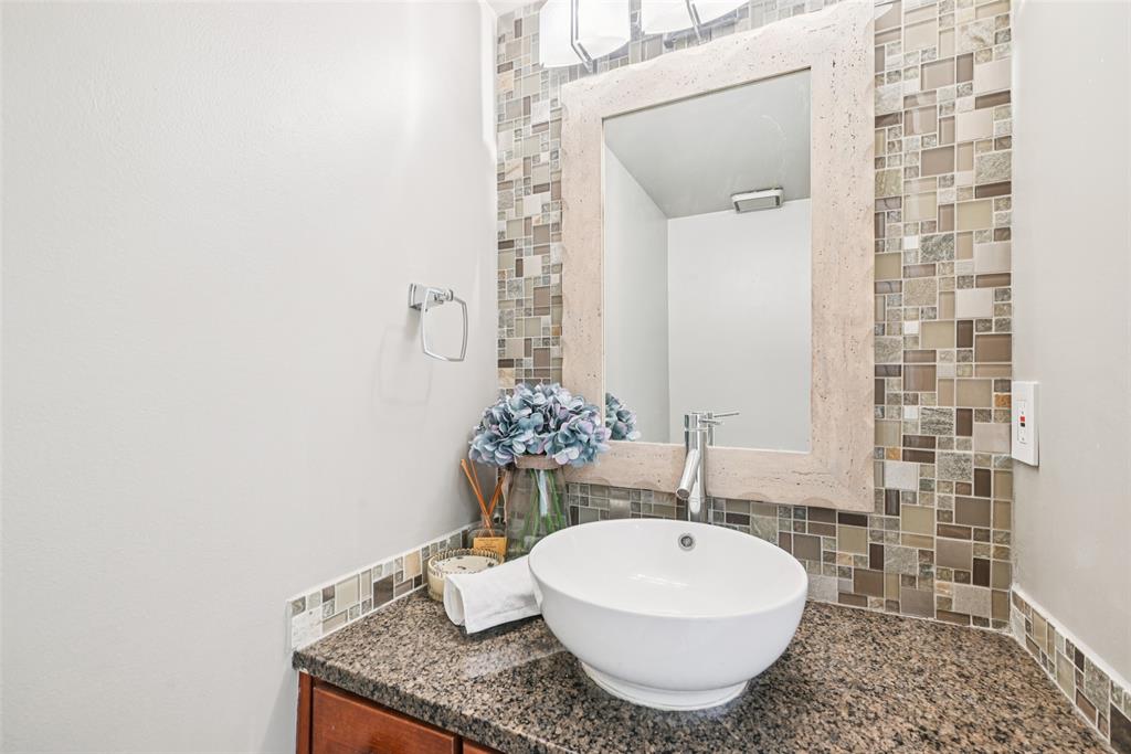 4102 Bowser Avenue, Unit 1 Dallas, TX 75219 - Photo 18 of 33 Chic half bath with vessel sink, granite counter, and mosaic tile accent wall.