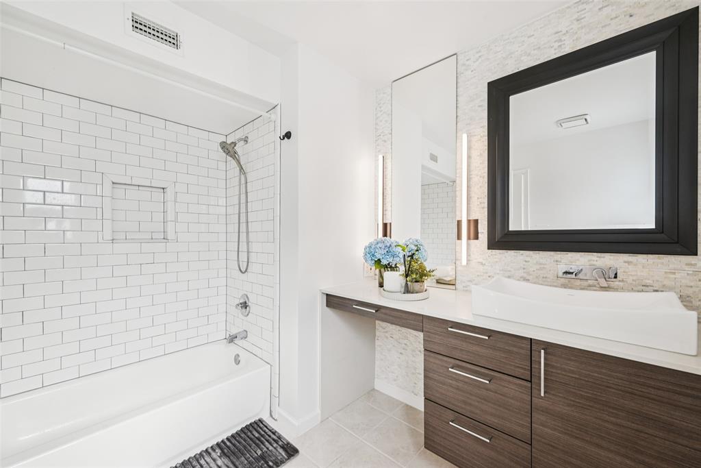 4102 Bowser Avenue, Unit 1 Dallas, TX 75219 - Photo 24 of 33 Updated ensuite bath features a subway-tiled tub-shower combo and refined tile accents.