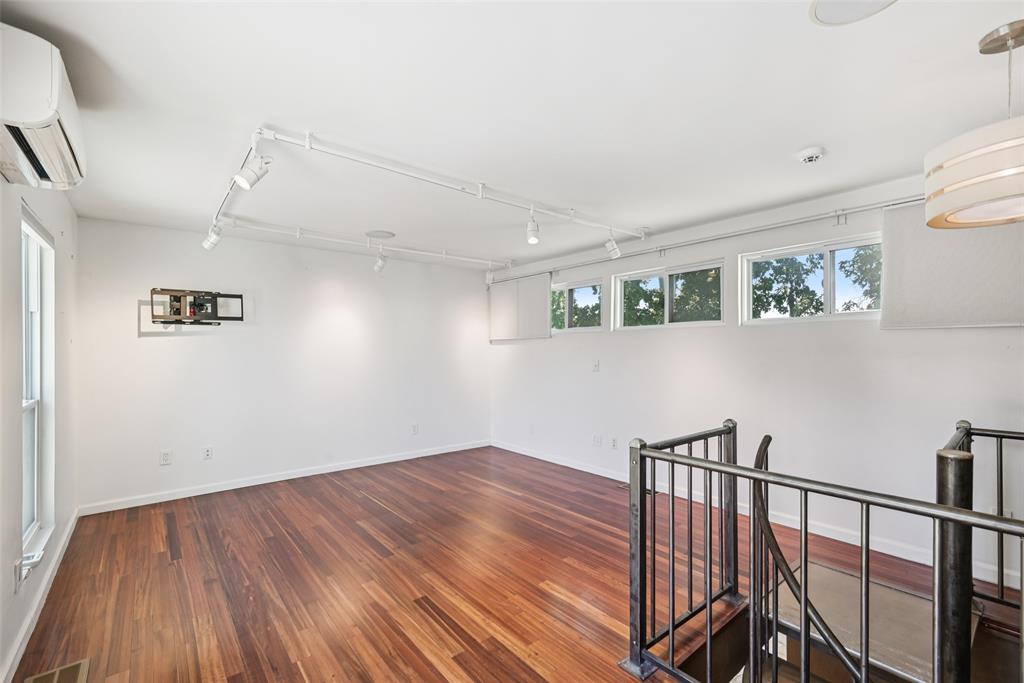 4102 Bowser Avenue, Unit 1 Dallas, TX 75219 - Photo 30 of 33 Wall-to-wall windows and warm wood flooring define this flexible top-level living space.