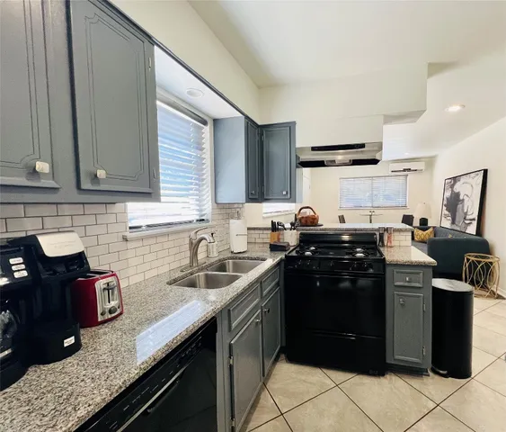 a kitchen with granite countertop a sink stove and cabinets