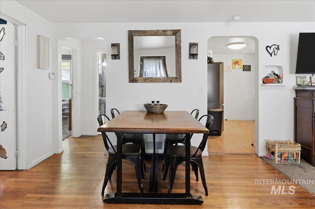 1958 East 1775 South Gooding, ID 83330 - Photo 18 of 49 Open dining area featuring wood-finish flooring, white painted walls, and an arched doorway