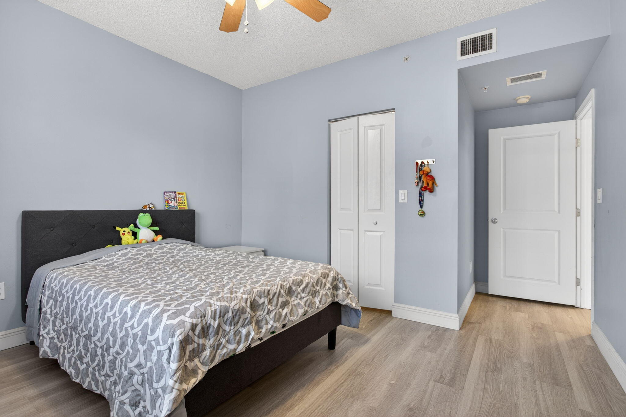 5880 West Sample Road, Unit 206 Coral Springs, FL 33067 - Photo 19 of 37 a bedroom with a bed and wooden floor